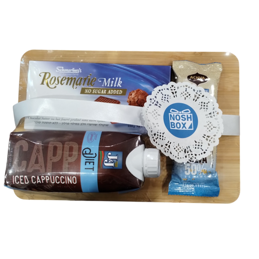 A gift package consisting of a bamboo board with a bar of Rosemarie no sugar added milk chocolate, no sugar Achva halva, and a J&J diet iced cappuccino, wrapped in clear plastic, with a white ribbon and a blue sticker with the Nosh Box logo on a lace doily border.